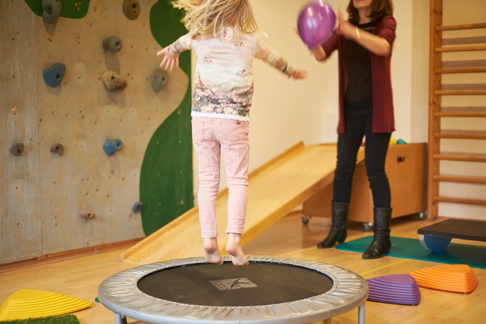 Kind beim Trampolinspringen in der Ergotherapie